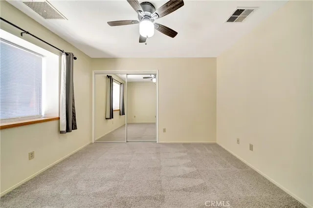an empty room with fan and windows