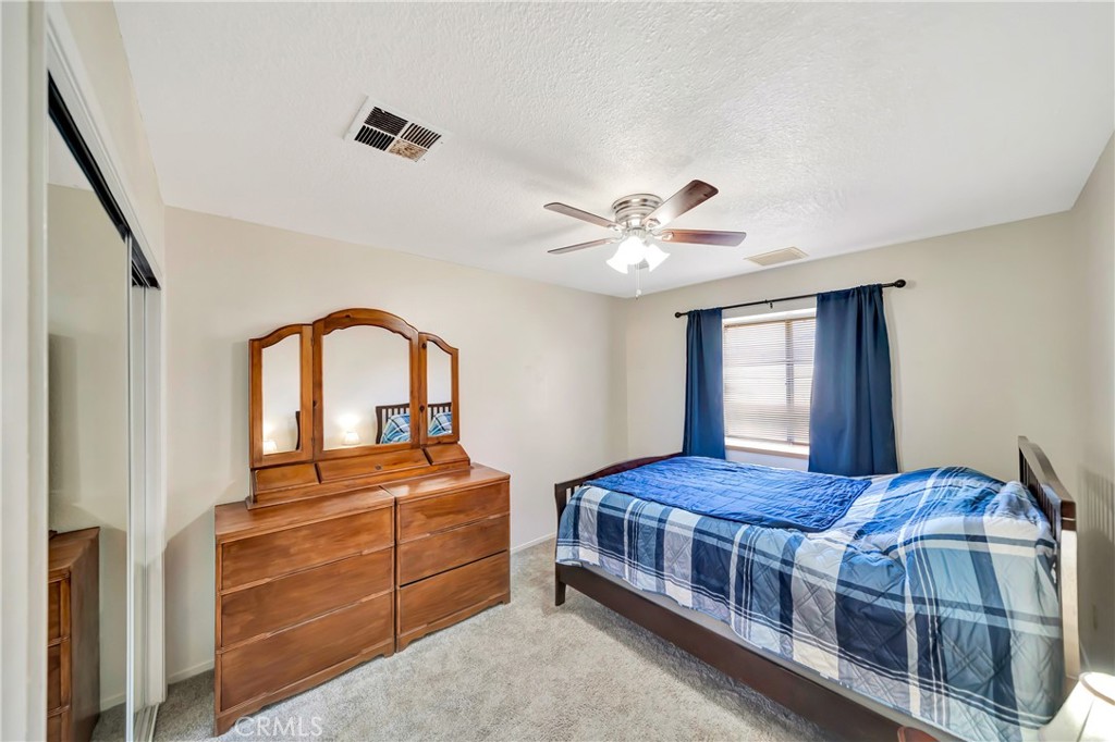 729 North Sunland Drive Ridgecrest, CA 93555 - Photo 37 of 52 a bedroom with a bed and a chandelier