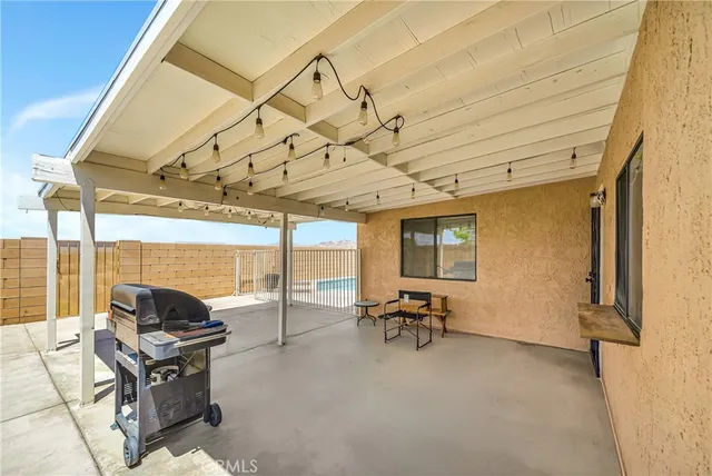 a view of a patio with a table and chairs under an umbrella
