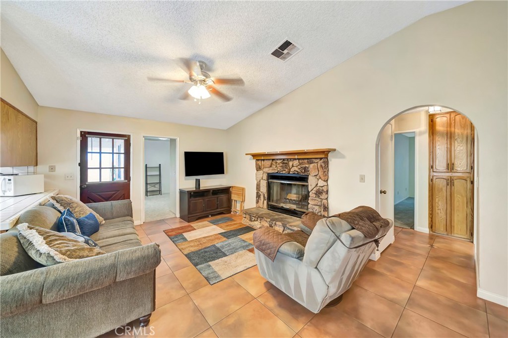 729 North Sunland Drive Ridgecrest, CA 93555 - Photo 9 of 52 a living room with furniture a fireplace and a flat screen tv