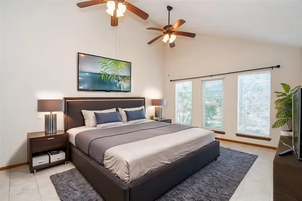 a bedroom with a large bed and a chandelier