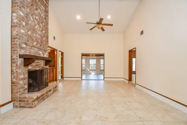 a view of an empty room with window and fireplace