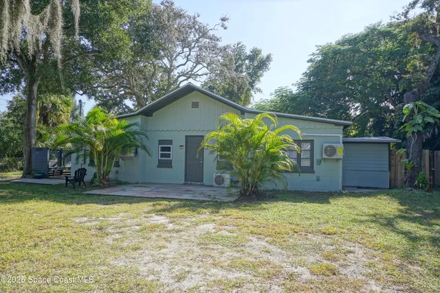 a view of a yard in front of a house with large tree