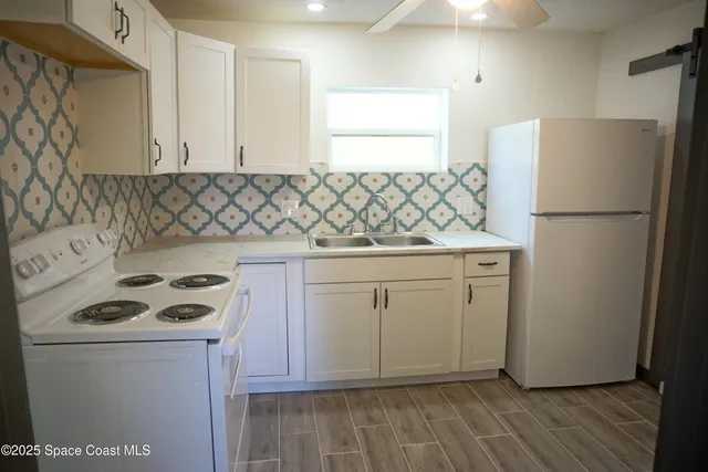 a kitchen with a refrigerator and a stove top oven