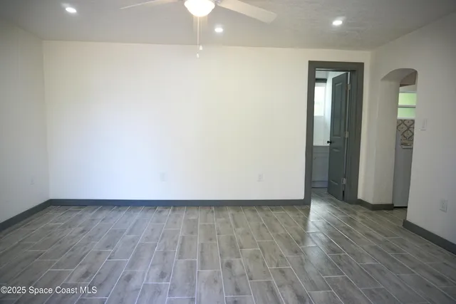 a view of an empty room with wooden floor and closet