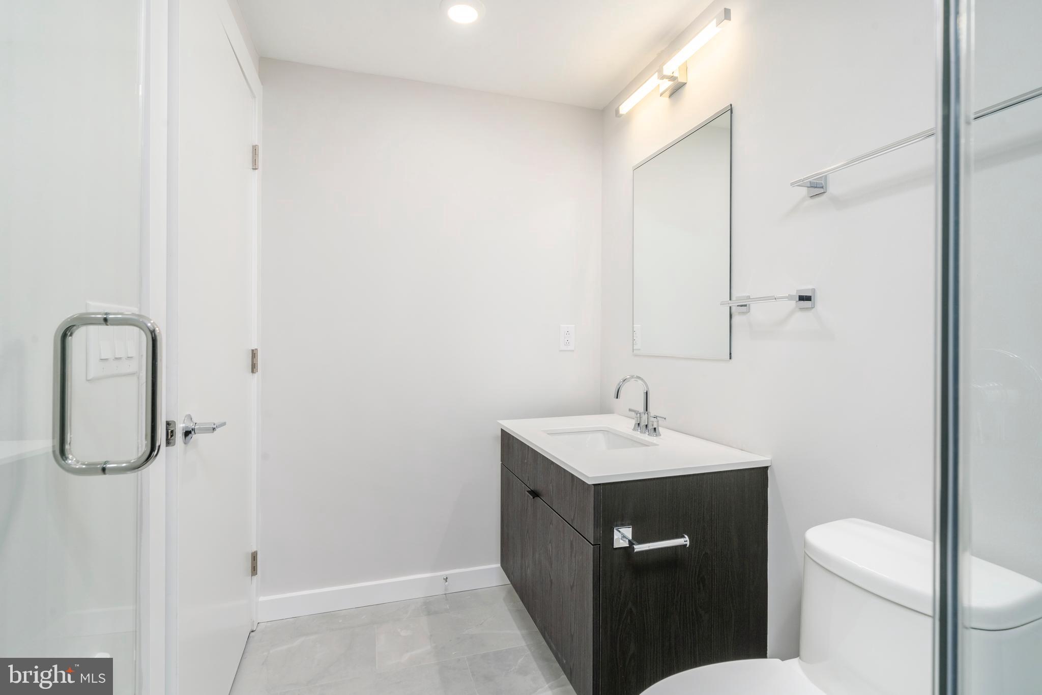 3449 Scotts Lane, Unit B221 Philadelphia, PA 19129 - Photo 19 of 21 a bathroom with a sink a toilet and shower