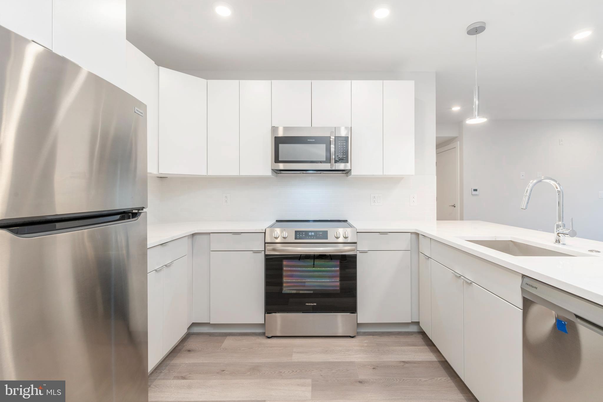 3449 Scotts Lane, Unit B221 Philadelphia, PA 19129 - Photo 2 of 21 a kitchen with stainless steel appliances granite countertop a refrigerator sink and stove