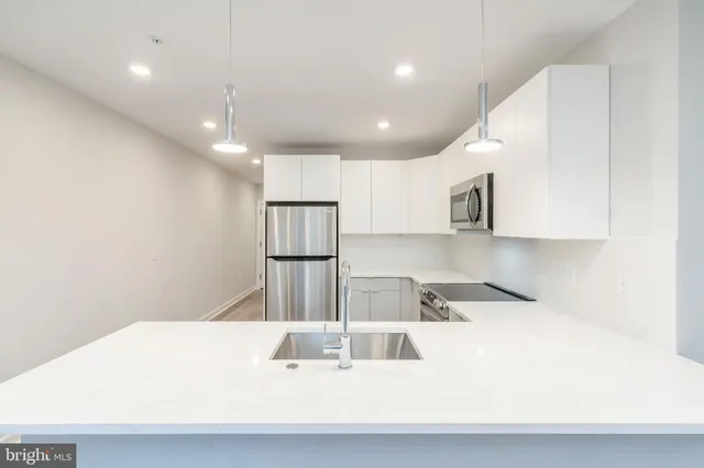 a kitchen with kitchen island a sink stainless steel appliances and cabinets