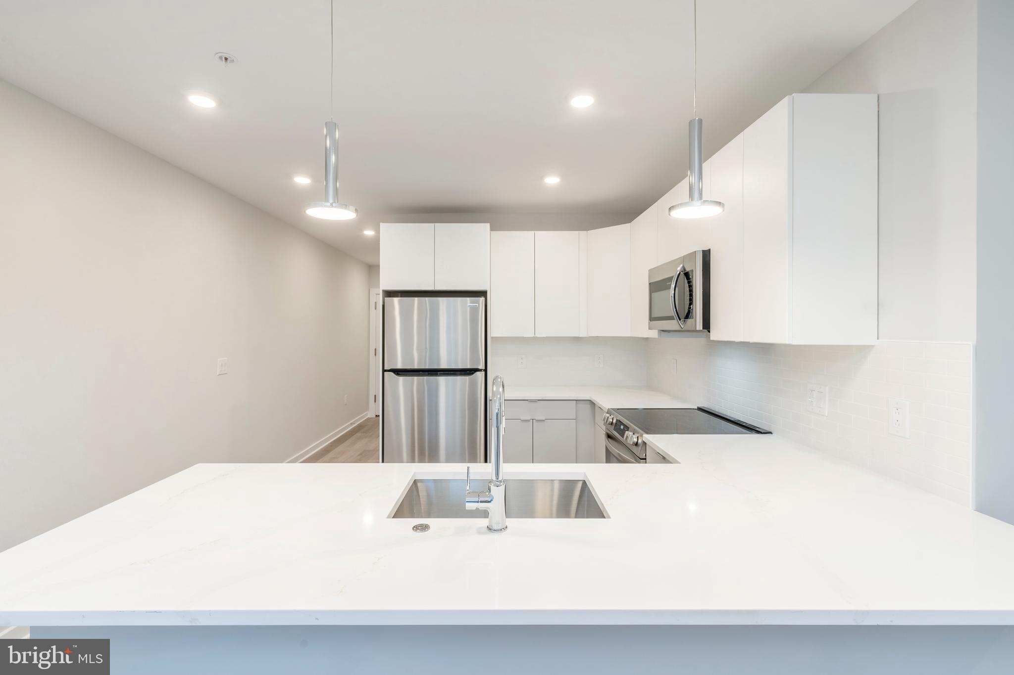 3449 Scotts Lane, Unit B221 Philadelphia, PA 19129 - Photo 6 of 21 a kitchen with kitchen island a sink stainless steel appliances and cabinets