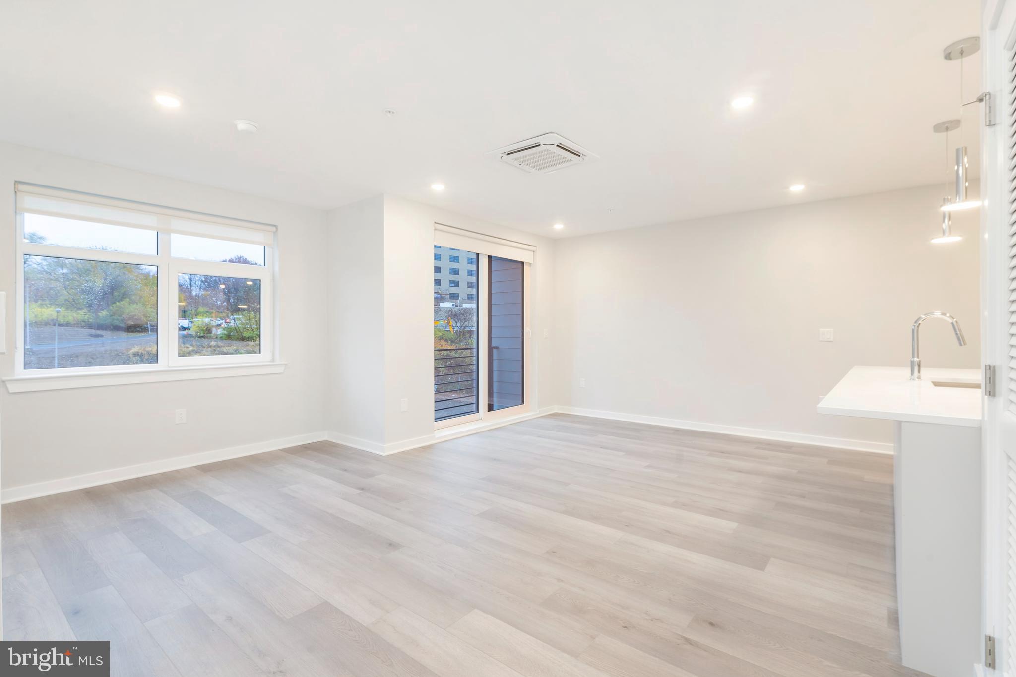 3449 Scotts Lane, Unit B221 Philadelphia, PA 19129 - Photo 7 of 21 an empty room with wooden floor and windows