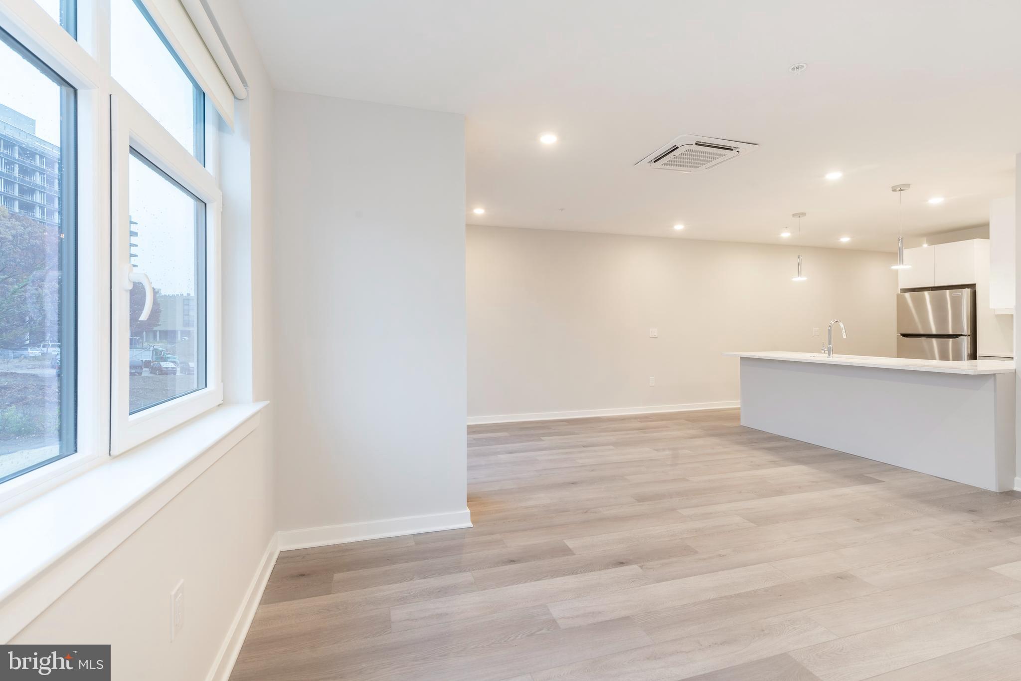 3449 Scotts Lane, Unit B221 Philadelphia, PA 19129 - Photo 8 of 21 a view of an empty room with wooden floor and a window