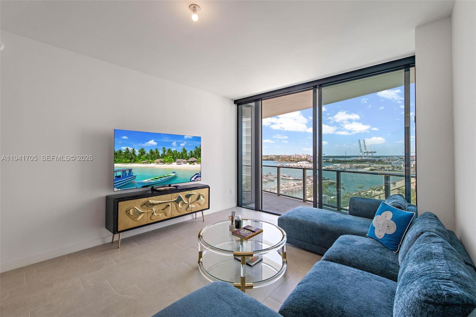 a living room with furniture floor to ceiling window and a flat screen tv
