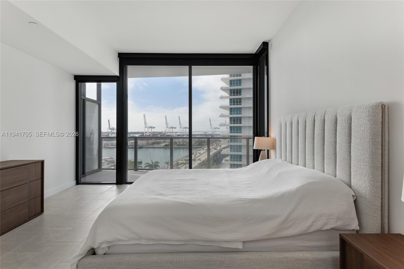 500 Alton Road, Unit 1204 Miami Beach, FL 33139 - Photo 4 of 22 a bedroom with a large bed and a large window