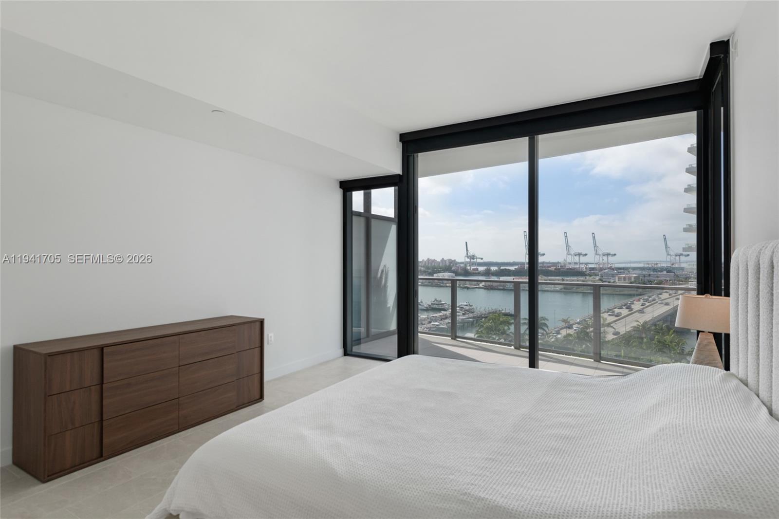 500 Alton Road, Unit 1204 Miami Beach, FL 33139 - Photo 5 of 22 a bedroom with a large bed and a large window