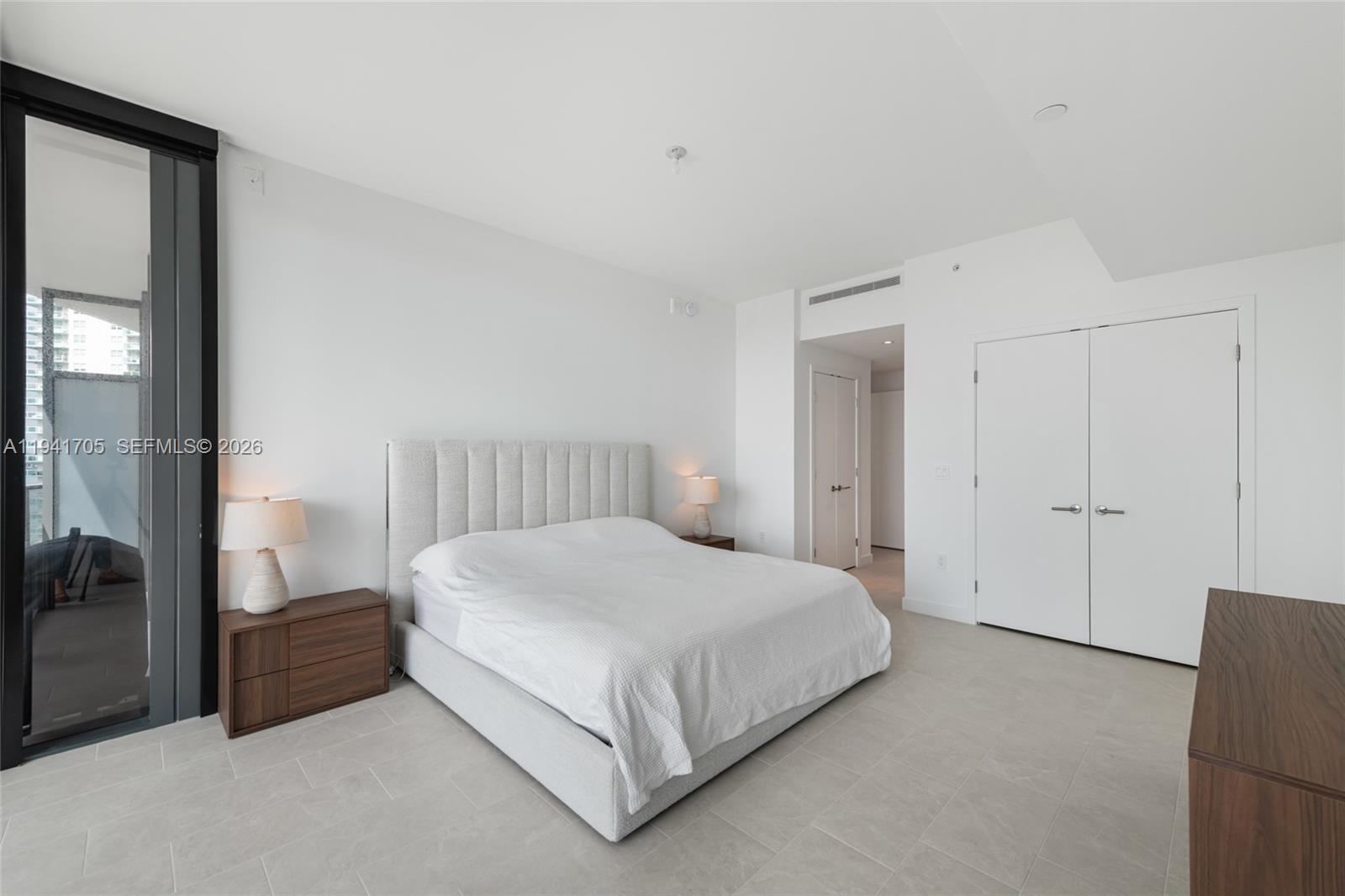 500 Alton Road, Unit 1204 Miami Beach, FL 33139 - Photo 6 of 22 a bedroom with a bed and a mirror
