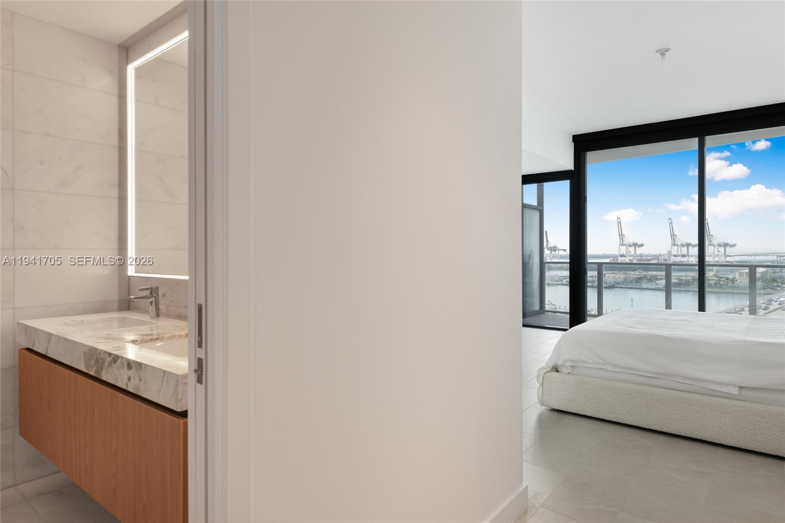500 Alton Road, Unit 1204 Miami Beach, FL 33139 - Photo 8 of 22 a bedroom with a bed and a large window