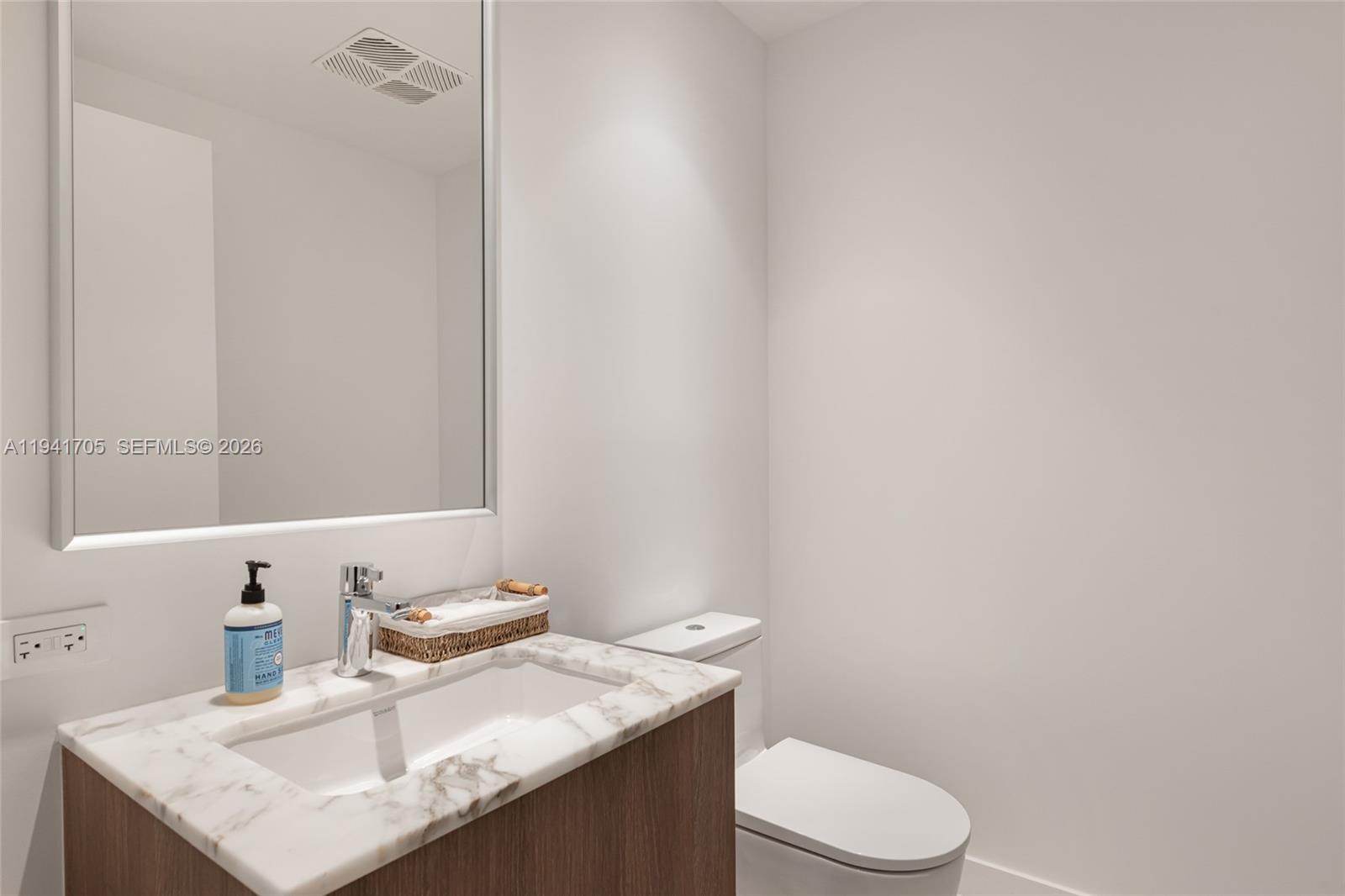 500 Alton Road, Unit 1204 Miami Beach, FL 33139 - Photo 10 of 22 a bathroom with a granite countertop sink toilet and mirror