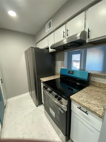 a kitchen with stainless steel appliances granite countertop a stove a refrigerator and a sink