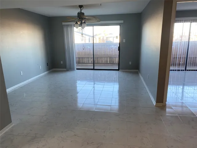 en empty room with windows and chandelier