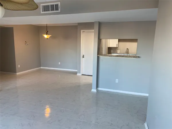 a view of an empty room with window and bathroom
