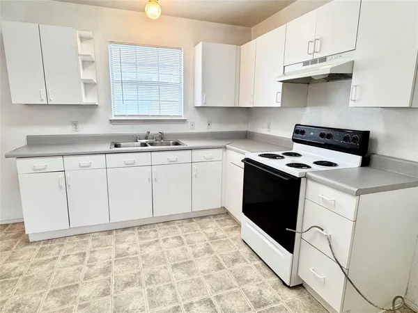 a kitchen with granite countertop white cabinets and white appliances