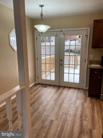 a view of an empty room with a window and a kitchen