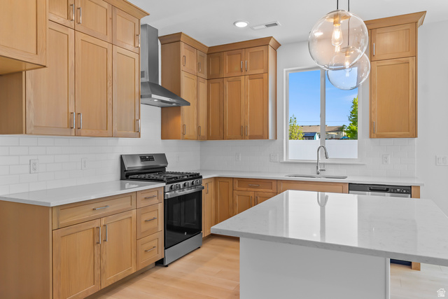 1237 West 500 South, Unit 230 Logan, UT 84321 - Photo 11 of 42 Kitchen featuring light wood cabinetry, stainless steel appliances, white subway tile backsplash, and a central island with a solid surface countertop