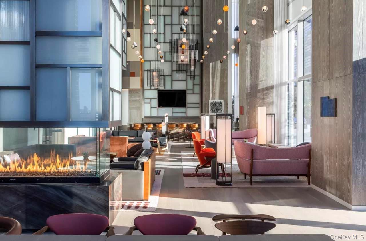 131-03 40 Road, Unit 18E Queens, NY 11354 - Photo 18 of 33 a room with furniture and a lamp