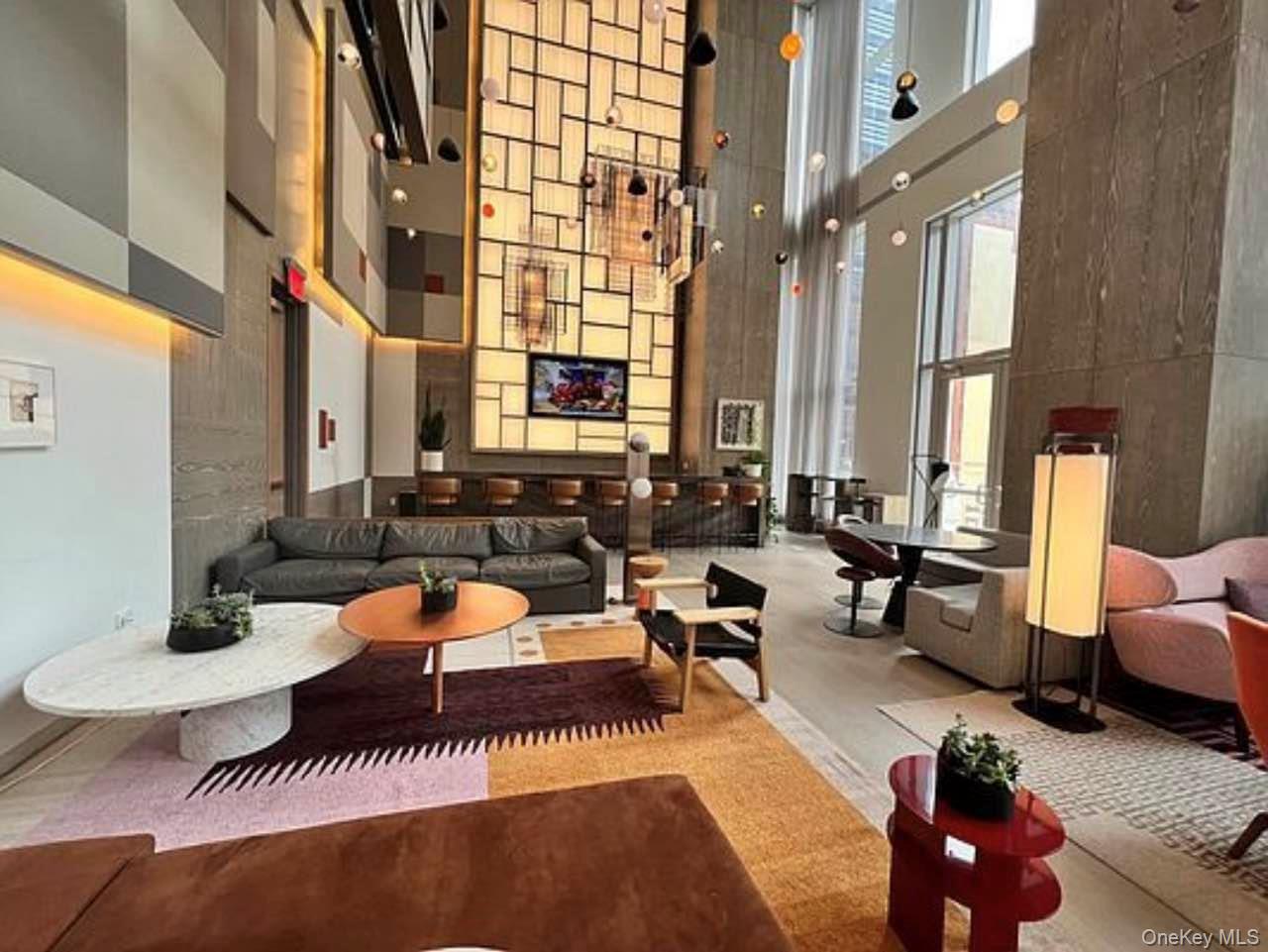 131-03 40 Road, Unit 18E Queens, NY 11354 - Photo 6 of 33 a living room with furniture and a large window