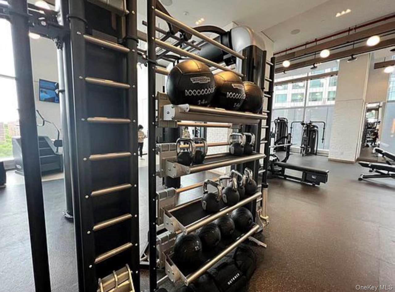 131-03 40 Road, Unit 18E Queens, NY 11354 - Photo 7 of 33 a view of walk in closet with clothes and shoes