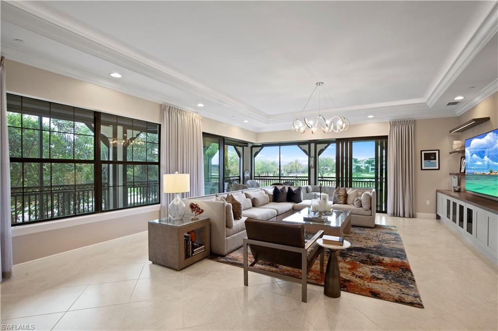 16391 Viansa Way, Unit 101 Naples, FL 34110 - Photo 13 of 48 a living room with furniture and large windows