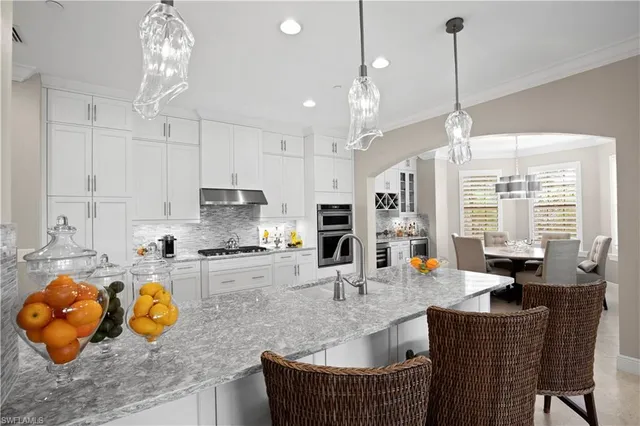 a kitchen with stainless steel appliances granite countertop a sink stove and cabinets