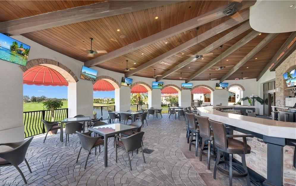 16391 Viansa Way, Unit 101 Naples, FL 34110 - Photo 44 of 48 a outdoor space with lots of tables a large window and chairs