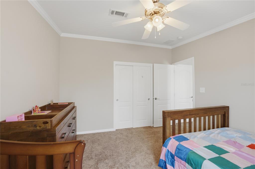 6844 Chad Jason Road St. Cloud, FL 34773 - Photo 26 of 59 a bedroom with a bed and a chandelier