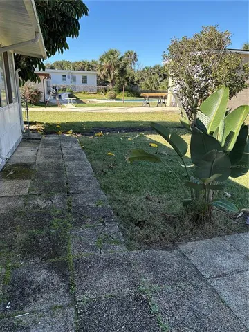 a view of yard with swimming pool and green space