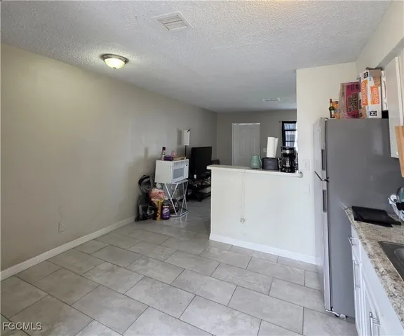 a view of a kitchen with fridge and workspace