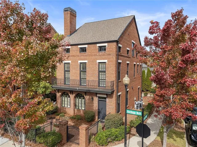 a front view of a house with glass windows and plants