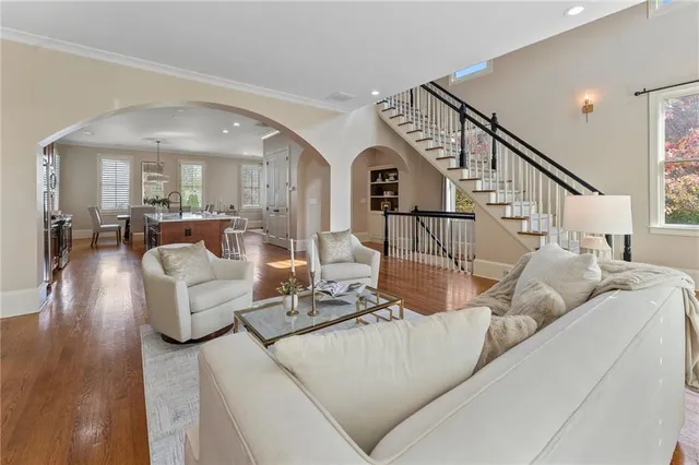 a kitchen with stainless steel appliances granite countertop a refrigerator a sink dishwasher a oven with white cabinets and wooden floor