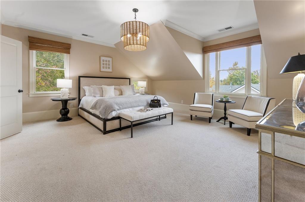 1950 Heritage Walk Alpharetta, GA 30004 - Photo 38 of 64 a spacious bedroom with a bed and a chandelier