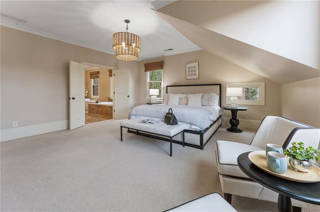 1950 Heritage Walk Alpharetta, GA 30004 - Photo 39 of 64 a spacious bedroom with a bed and a chandelier