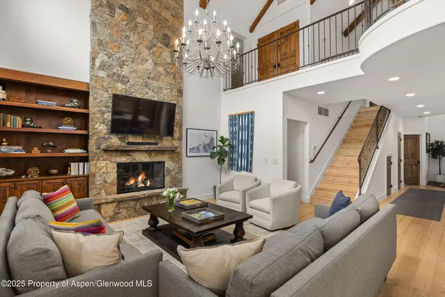 a living room with furniture a flat screen tv and a fireplace