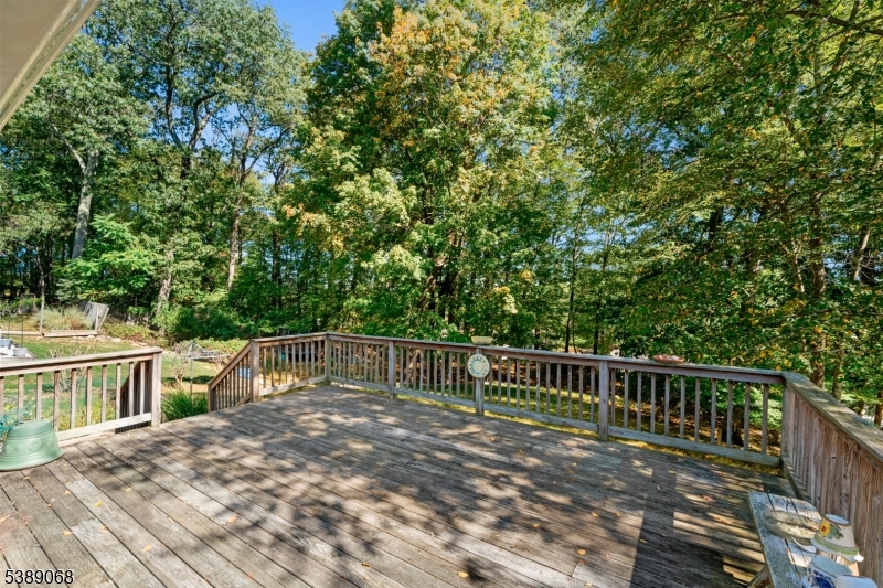 53 White Meadow Road Rockaway, NJ 07866 - Photo 20 of 40 a view of a deck with two chairs and a table