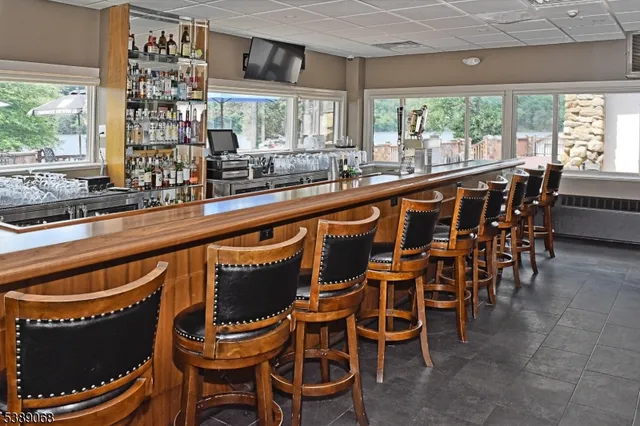 a kitchen with a dining table chairs and large windows