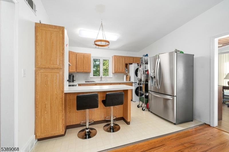 53 White Meadow Road Rockaway, NJ 07866 - Photo 7 of 40 a kitchen with stainless steel appliances a refrigerator and wooden floor
