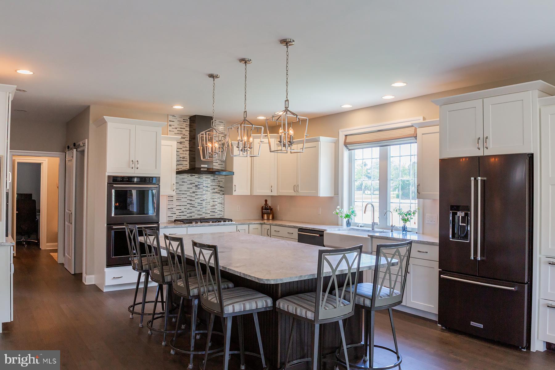 425 East Delp Road Lancaster, PA 17601 - Photo 33 of 109 a kitchen with stainless steel appliances granite countertop a dining table chairs refrigerator and microwave