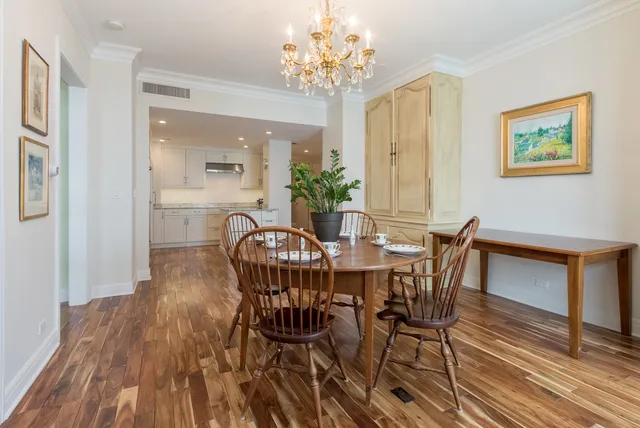 a view of a dining room with furniture a chandelier and wooden floor