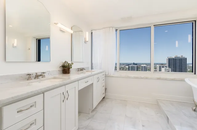 a spacious bathroom with a granite countertop sink mirror and bathtub