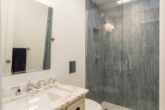 a bathroom with a sink shower and a mirror