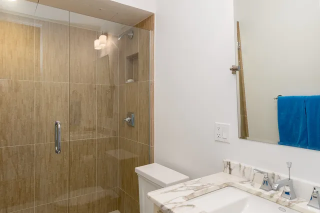 a bathroom with a granite countertop sink a shower and a mirror