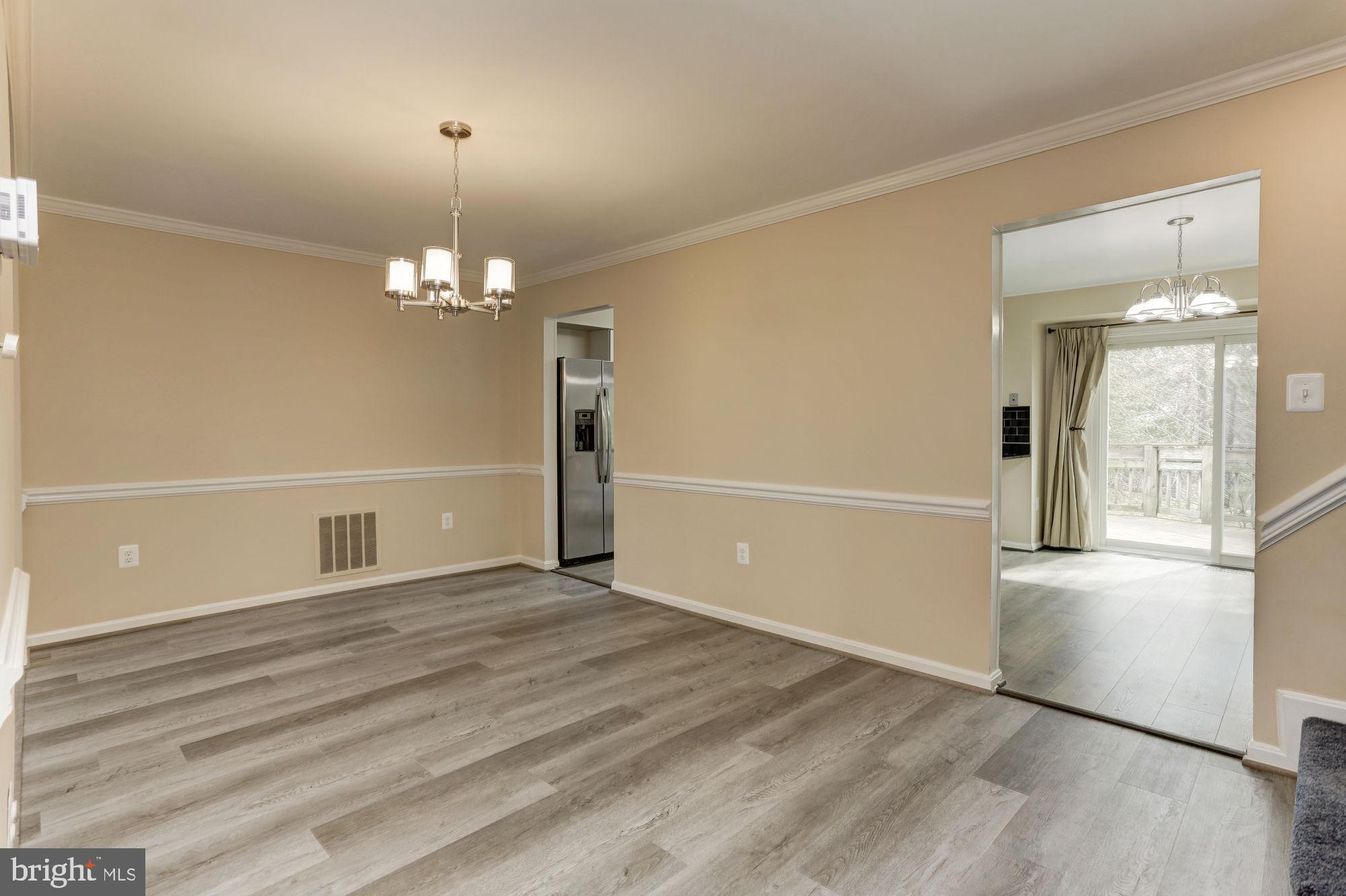 10107 Galsworthy Place Bethesda, MD 20817 - Photo 13 of 62 an empty room with wooden floor mirror and windows